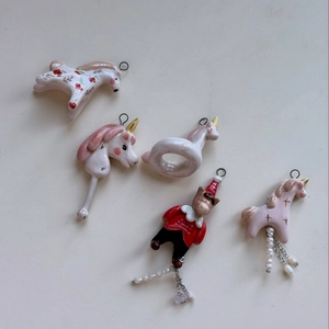 Detailed macro view of ceramic animal pendants with gold accents and pearl tassels