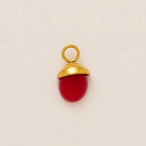 Détail d'un pendentif gland plaqué or 18k avec une pierre rouge polie sertie