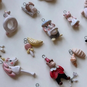 Flat lay of colorful ceramic animal charms like pigs and elephants with metal rings