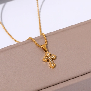 Detail of 18k gold plated stainless steel cross pendant necklace with zircon inlay