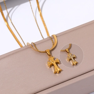 Detailed view of an 18k gold plated stainless steel cross pendant on a snake chain