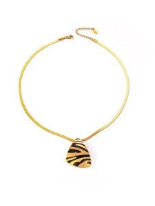 Detail view of a gold snake chain necklace with a black tiger-print triangle pendant