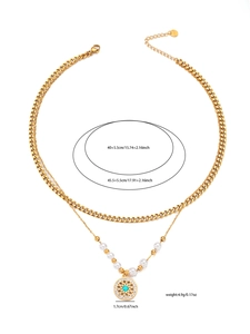Dettaglio della collana a doppio strato dorata con ciondolo turchese e perle