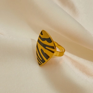 Detail of adjustable gold ring featuring a black animal print shield on satin fabric