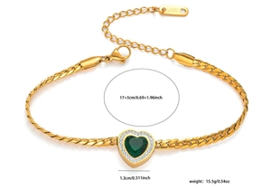 Detail of gold snake chain bracelet featuring a green heart zircon and S.STEEL stamp