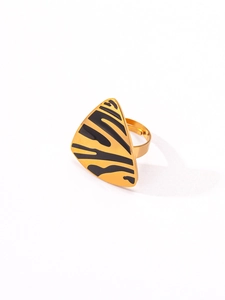 Macro detail of triangular gold ring with black animal print enamel and vintage finish