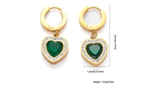 Detailed view of heart-shaped gold earrings with green gemstone and white stone halo
