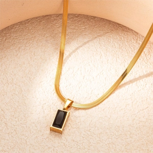 Detail of gold snake chain necklace featuring a rectangular black gemstone pendant