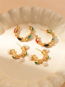 Gros plan de boucles d'oreilles vintage en acier titane avec perles et pierres colorées sur plateau