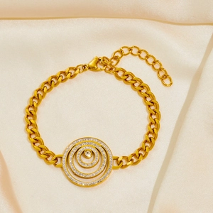 Macro view of gold chain bracelet with triple concentric circles and white crystal details