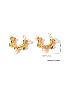 Détail des boucles d'oreilles en C dorées rétro avec perles et pierres vertes
