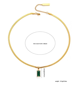 Detail of gold snake chain necklace featuring green emerald pendant and Good Luck tag
