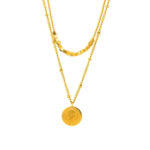 Dettaglio di una collana dorata a strati con catena a serpente e ciondolo a moneta retro