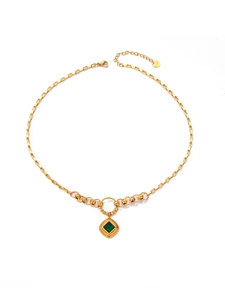 Macro shot of square-cut emerald pendant on gold-plated box chain with S.Steel engraving