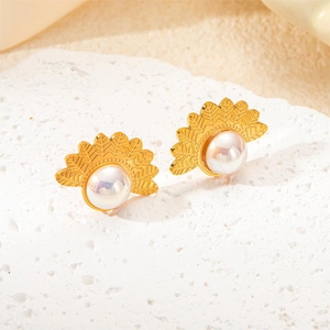 Detailed view of golden sunburst fan earrings with pearls on white stone display