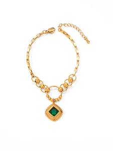 Detailed view of emerald cut green gemstone on a vintage gold chain with lobster clasp