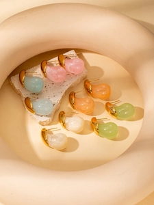 Detailed macro shot of minimalist resin teardrop earrings in five soft colors on stone