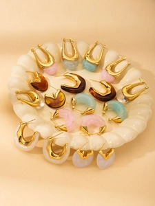 Retro gold chunky hoop earrings with colorful resin drops on a ceramic display