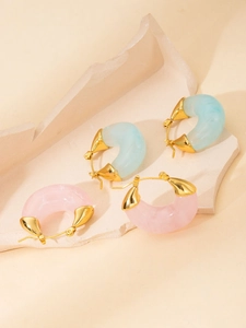 Detail of C-shaped resin earrings in pink and blue with 18K gold plated metal base