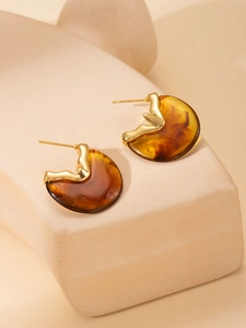 Detailed close-up of amber resin earrings with elegant golden metallic trim accents
