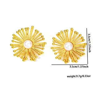 French vintage sunburst flower gold earrings with central pearl on white background