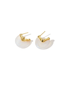 Macro detail of gold wavy earrings with iridescent pearly inlay on white background
