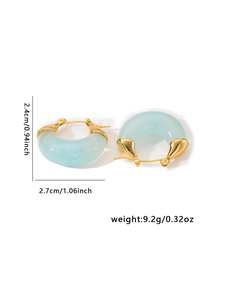 Macro shot of C-shaped titanium earrings in blue resin with gold metal accents