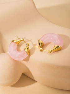 Detail of pink marble resin C-shaped hoop earrings with gold-plated metal studs