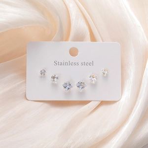 Détail de trois paires de boucles d'oreilles en acier inoxydable avec zircons carrés