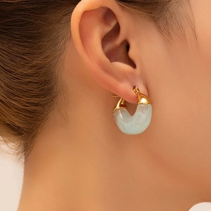 Eleganti orecchini a forma di C placcati oro 18K e resina azzurra su modella donna