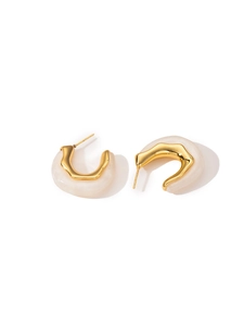 Macro detail of wave-shaped gold titanium steel earrings with white resin inlay