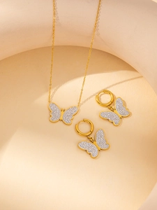 Detailed view of gold butterfly jewelry set with pavé rhinestones on necklace and earrings