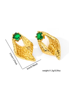 Macro shot of gold-plated drop earrings featuring hammered texture and emerald green stones