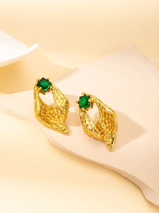 Detailed shot of gold irregular geometric earrings with square green zircon on stone