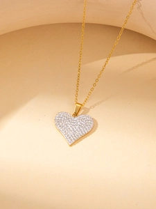 Detailed view of a gold heart pendant necklace with shimmering white pavé zircon stones