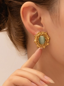 Detailed macro view of vintage gold stud earring with green gemstone on the earlobe
