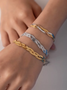 Detailed view of woven herringbone chains in gold, silver and tri-color finishes