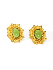 Detail of vintage gold earrings with green oval gemstones and leaf patterns