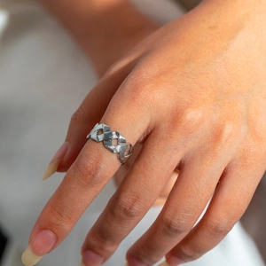 Macro shot of a silver titanium steel woven hollow ring with a brushed metal texture