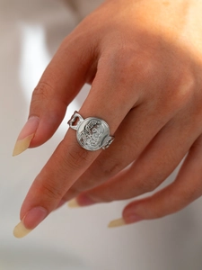 Macro shot of silver retro titanium steel ring with coin relief and hollow chain band