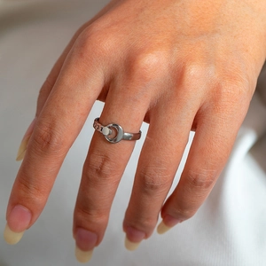 Detail of silver titanium ring with hollow circle design and cuban chain texture