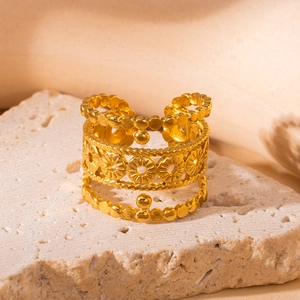 Nahaufnahme von goldenem Titanstahlring mit hohler Sonnenblume und Perlenstruktur