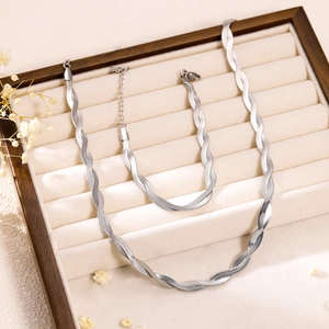 Close-up of silver twist chain necklace and bracelet set in a velvet jewelry box