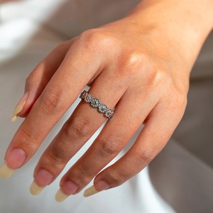 Detail of silver daisy chain ring on hand featuring vintage floral texture design