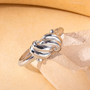 Macro shot of silver spiral twisted ring with polished finish on stone surface