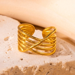 Makroaufnahme von vergoldetem mehrlagig verschlungenem Ring auf minimalistischem Stein