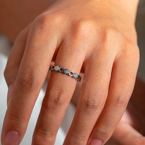 Close-up of a silver chain-link titanium steel ring with unique hollow circular design