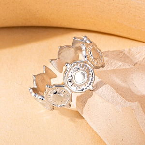 Close-up of vintage silver open ring featuring sun relief disk and fishtail detail
