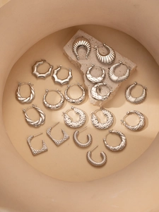 Dettaglio set di orecchini in acciaio al titanio argento con cerchi e motivi geometrici