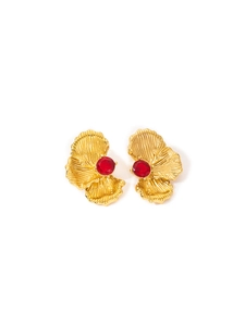 Detailed macro view of vintage gold plated flower earrings with sparkling red zircon